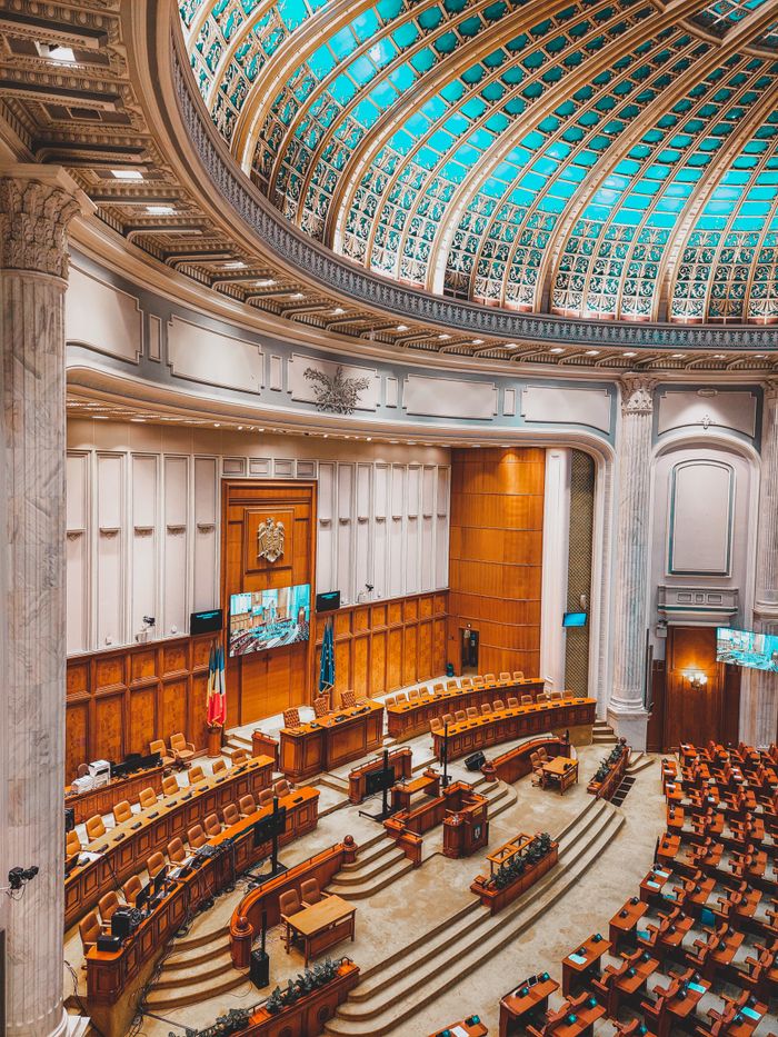 Stunning view of a grand parliamentary chamber in Europe, featuring ornate architecture and empty seating.