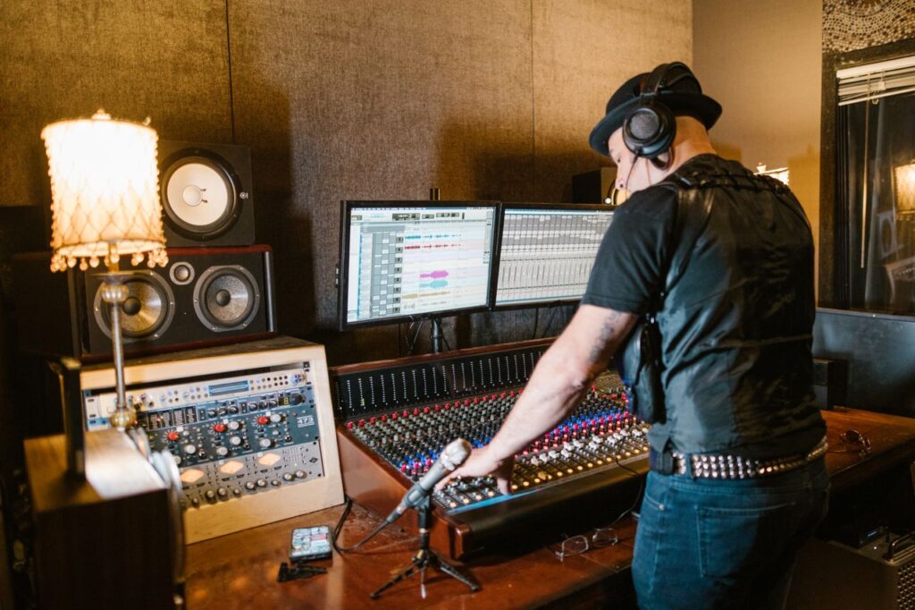 A music producer at the mixing console in a professional recording studio.